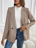 Model wearing a brown and black plaid blazer with lapel collar and button closure.