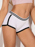 Close-up of white yoga shorts with black striped trim and boxer-style fit