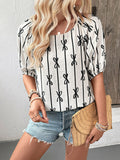 A woman wearing a white short-sleeve blouse with a black vertical stripe and bow pattern, featuring a square neck and puff sleeves.