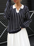 Model wearing a navy and white vertical striped knit sweater with a collared V-neck design