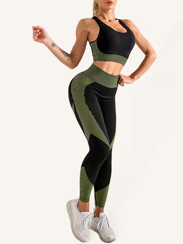 A woman wearing a black and olive green textured two-piece yoga outfit set including a racerback tank top and high-waisted leggings.