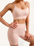 Model wearing a peach colored seamless camisole sports bra and matching high-waisted gym shorts set.