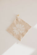 Lazy Daisy lovey featuring a soft floral knit pattern in neutral beige and cream colors.
