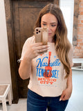 Woman wearing a Nashville Tennessee guitar graphic print top paired with casual bottoms.