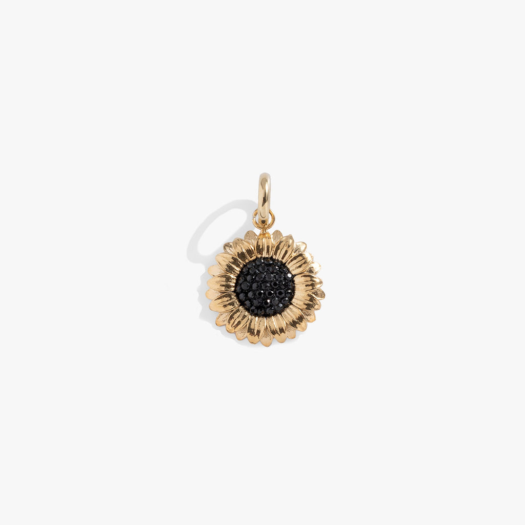 Gold-tone sunflower charm with a center of faceted black crystals.