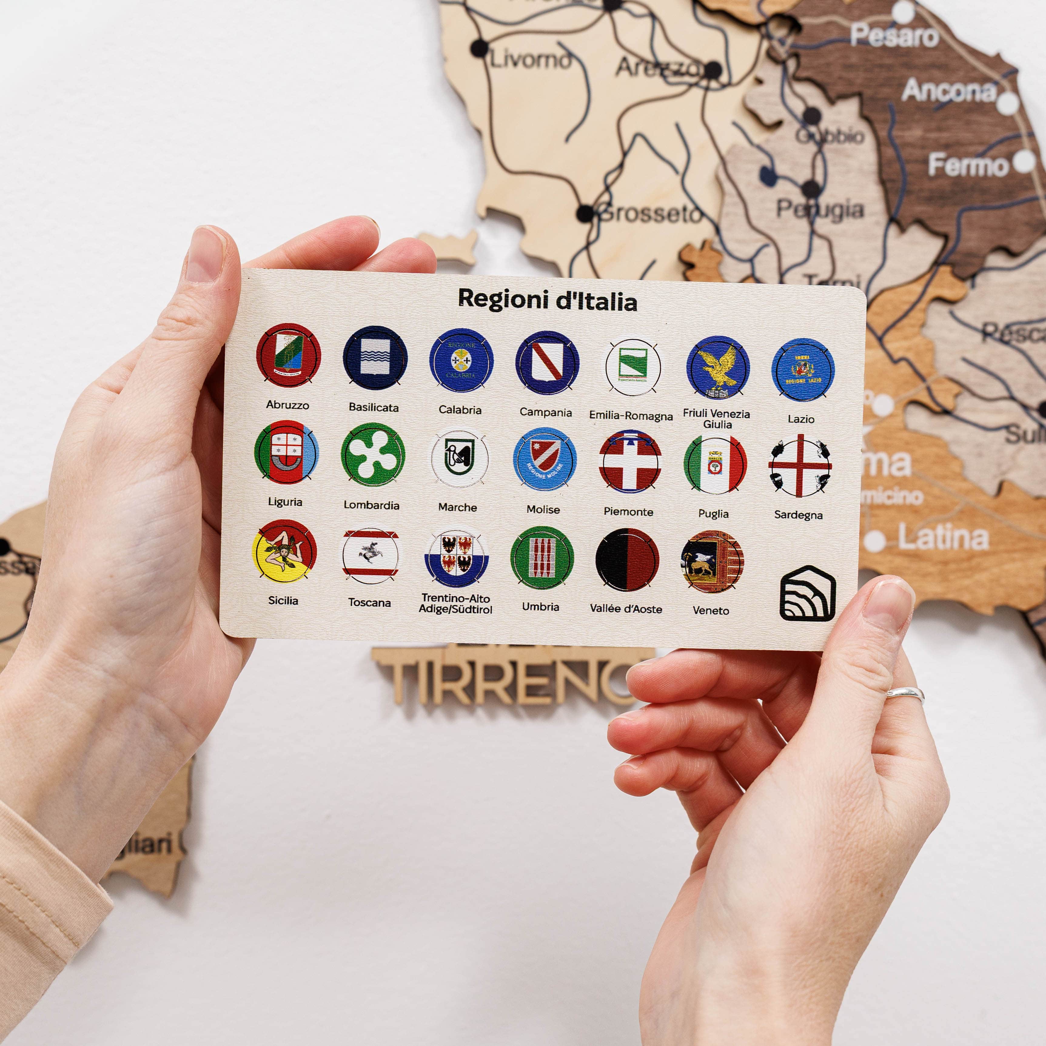 Vibrant, small circular Italy regional flag pins featuring red, white, green, and gold colors on a travel map.