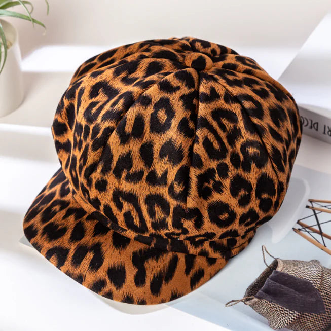 Close up top view of a brown and black leopard print octagonal cotton newsboy style hat.