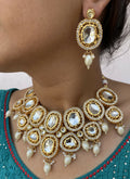 Artisan gold-plated Kundan necklace set on a luxury display