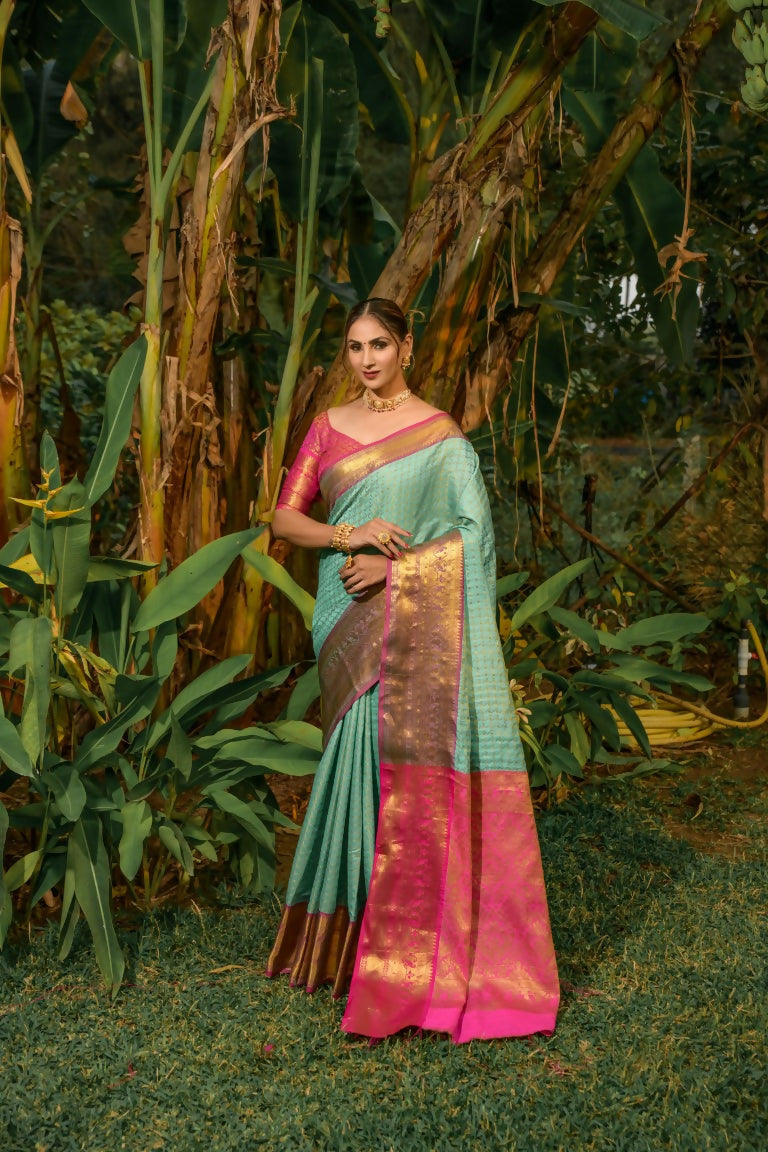 Sky blue Kanjivaram silk saree with Zari woven details and a contrasting pink blouse.