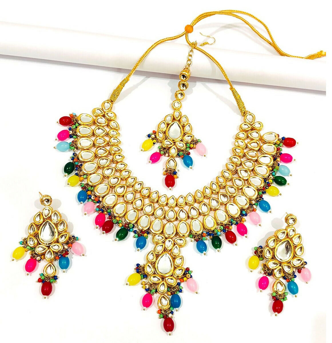 Hand-made gold-plated Kundan stone necklace and earring set on a display