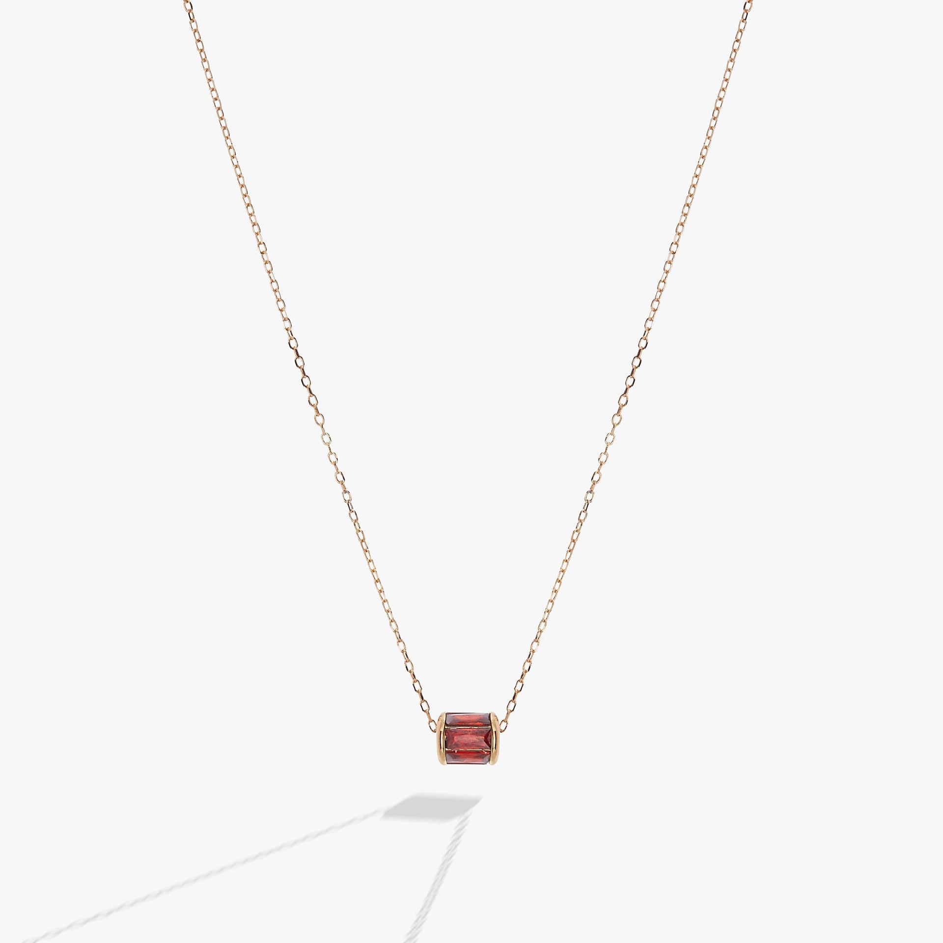 January birthstone necklace featuring a barrel-shaped scarlet crystal in a 14K gold setting