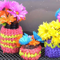 A crochet jar cozy wrapped around a glass mason jar on a wooden table.
