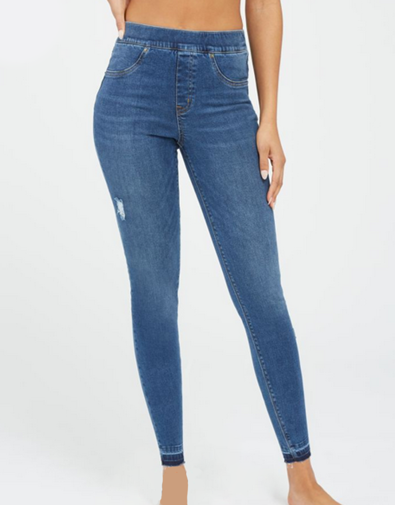 Woman wearing high-rise distressed ankle skinny jeans in medium indigo blue wash