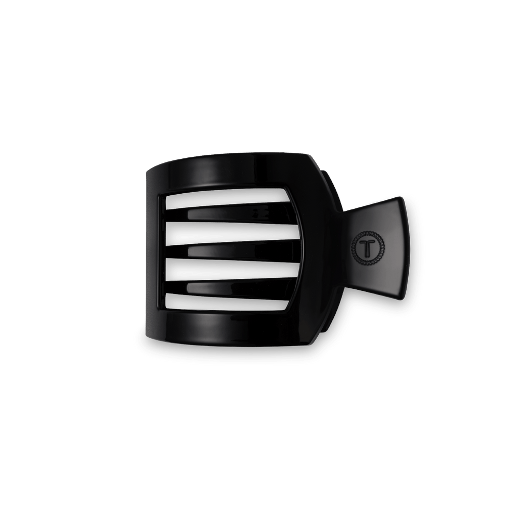 Small square hair clip in black against a clean backdrop