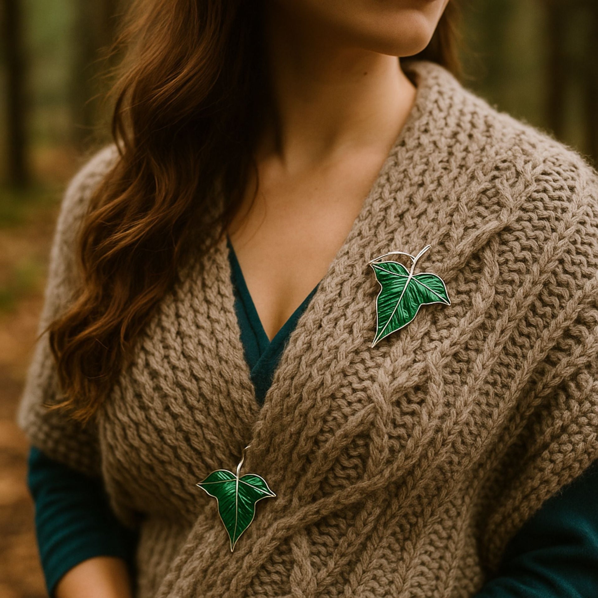 Set of two emerald green leaf brooches with silver-tone edges, styled as both pins and pendants.