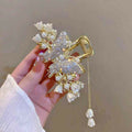 A white butterfly-shaped metal hair claw clip resting on a neutral background
