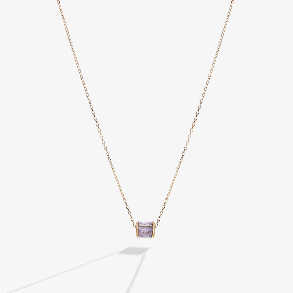 Minimalist gold chain necklace featuring a small, baguette-cut light purple amethyst crystal pendant.