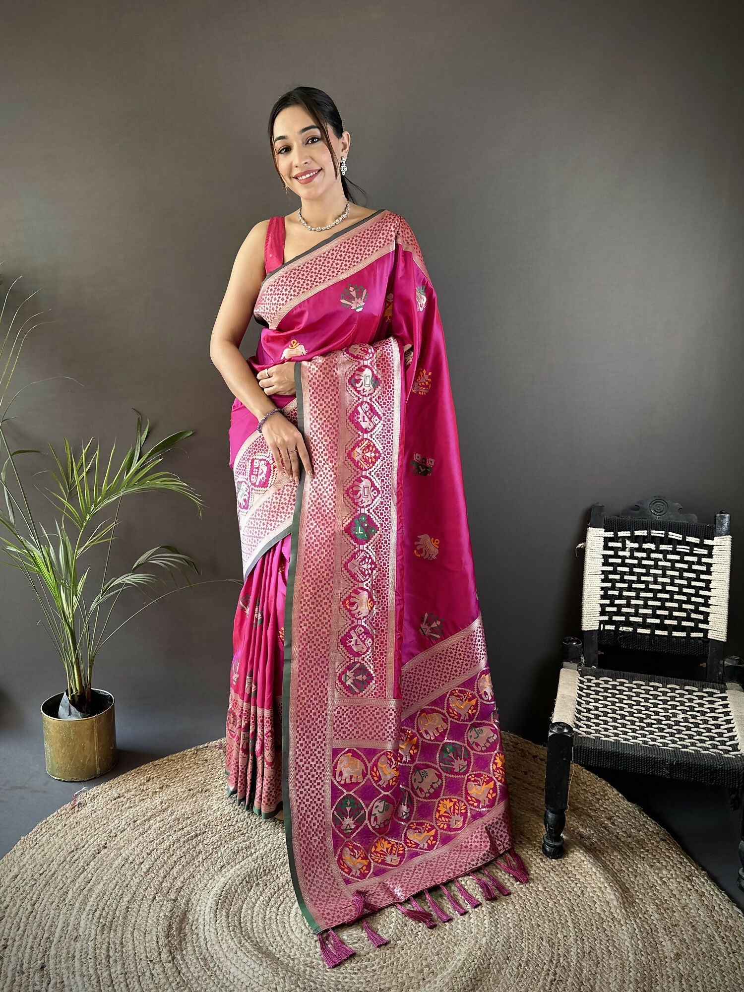 Pink Banarasi saree featuring elephant and floral motifs with a contrasting green blouse