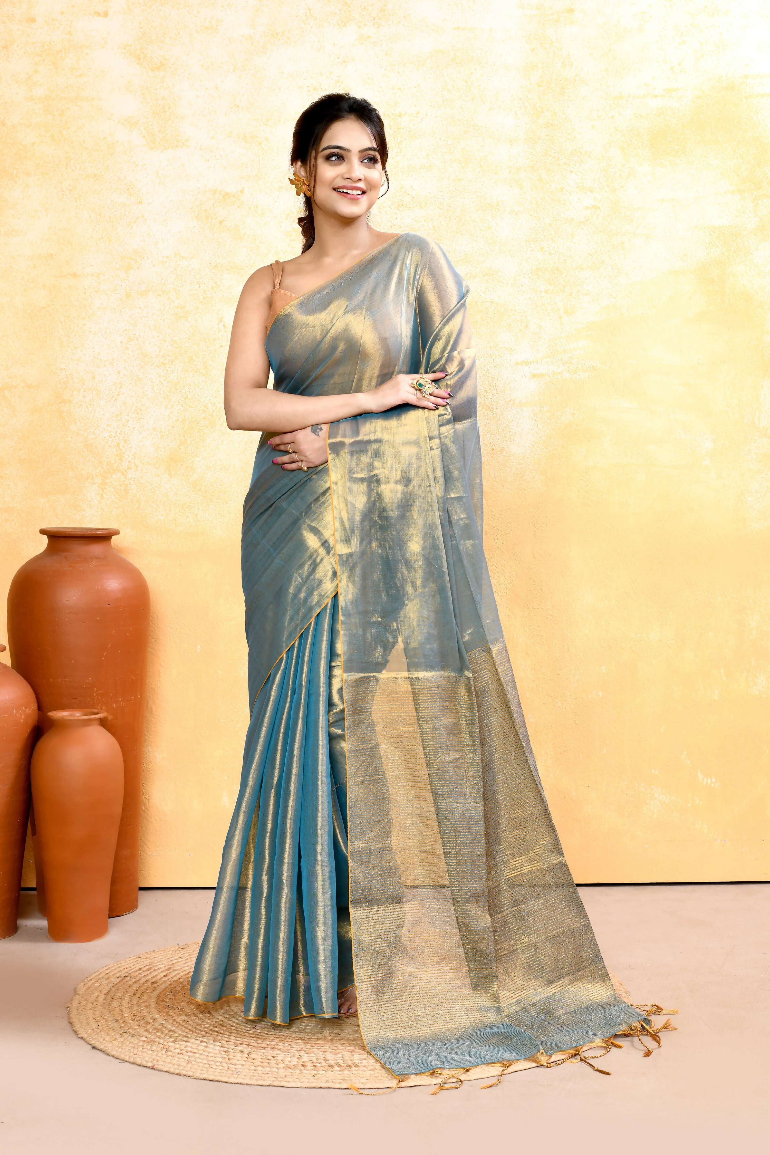 Copper and turquoise dual-tone organic tissue saree with a matching blouse piece displayed