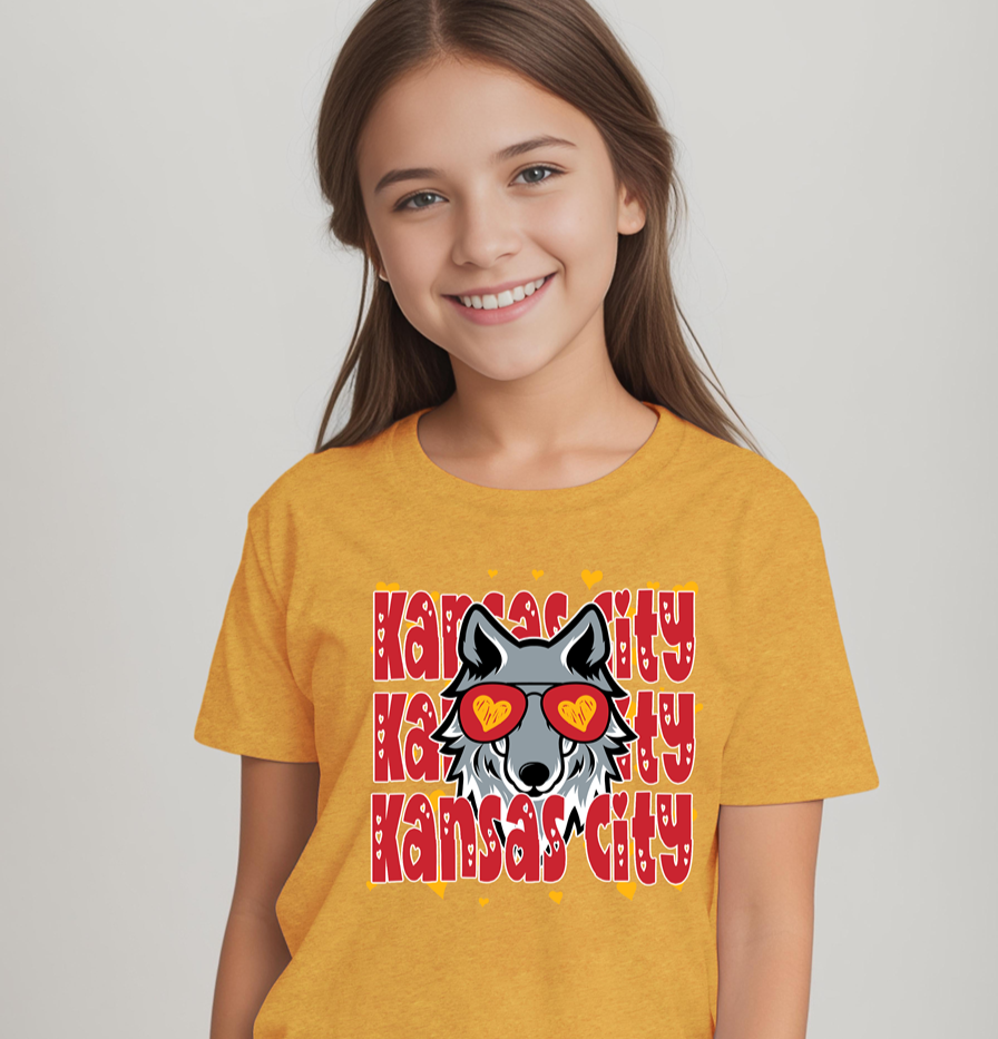 Young girl wearing a heather mustard youth t-shirt featuring a Kansas City wolf graphic with heart-shaped glasses.