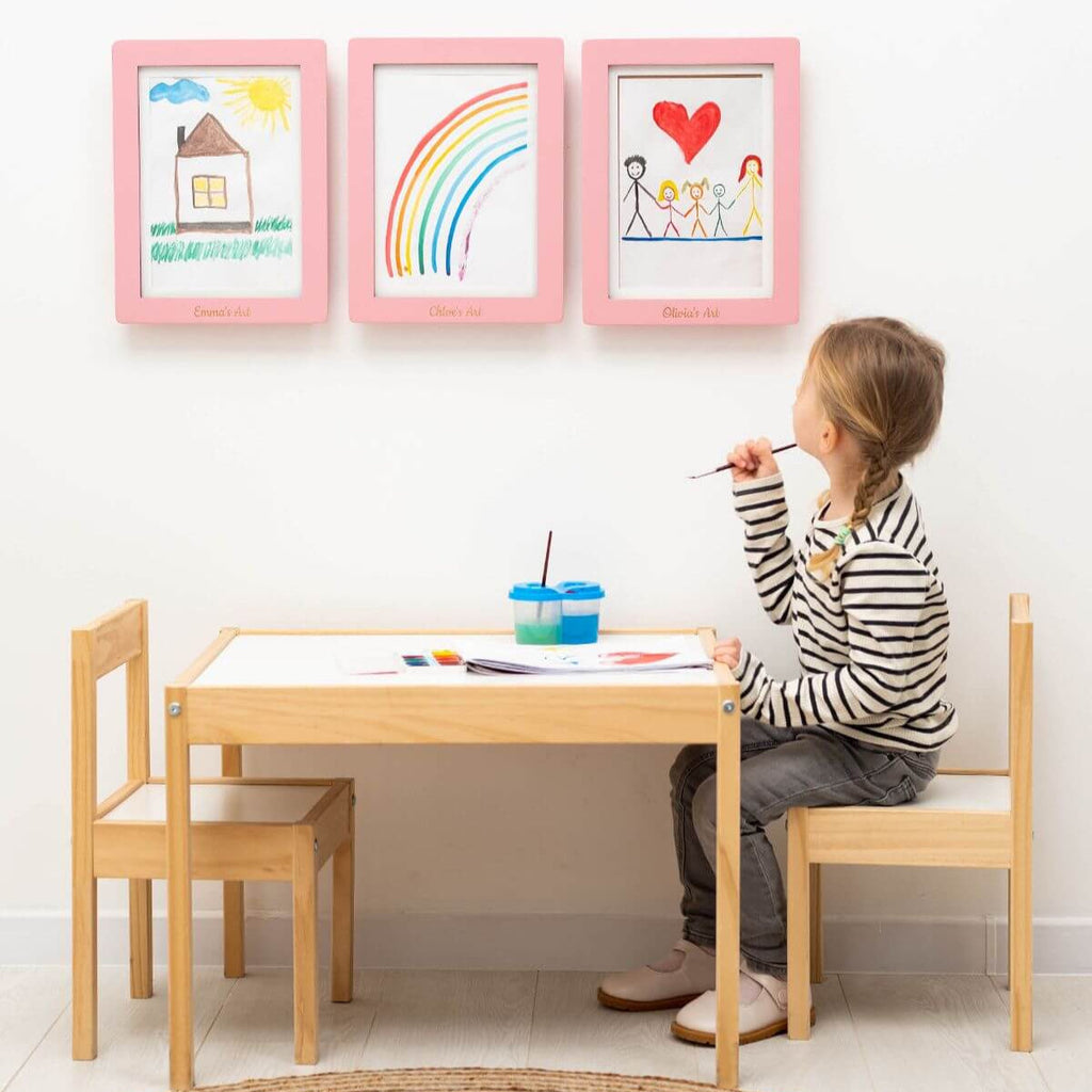 Minimalist A4 kids art display frame in light wood and pink finishes for gallery wall