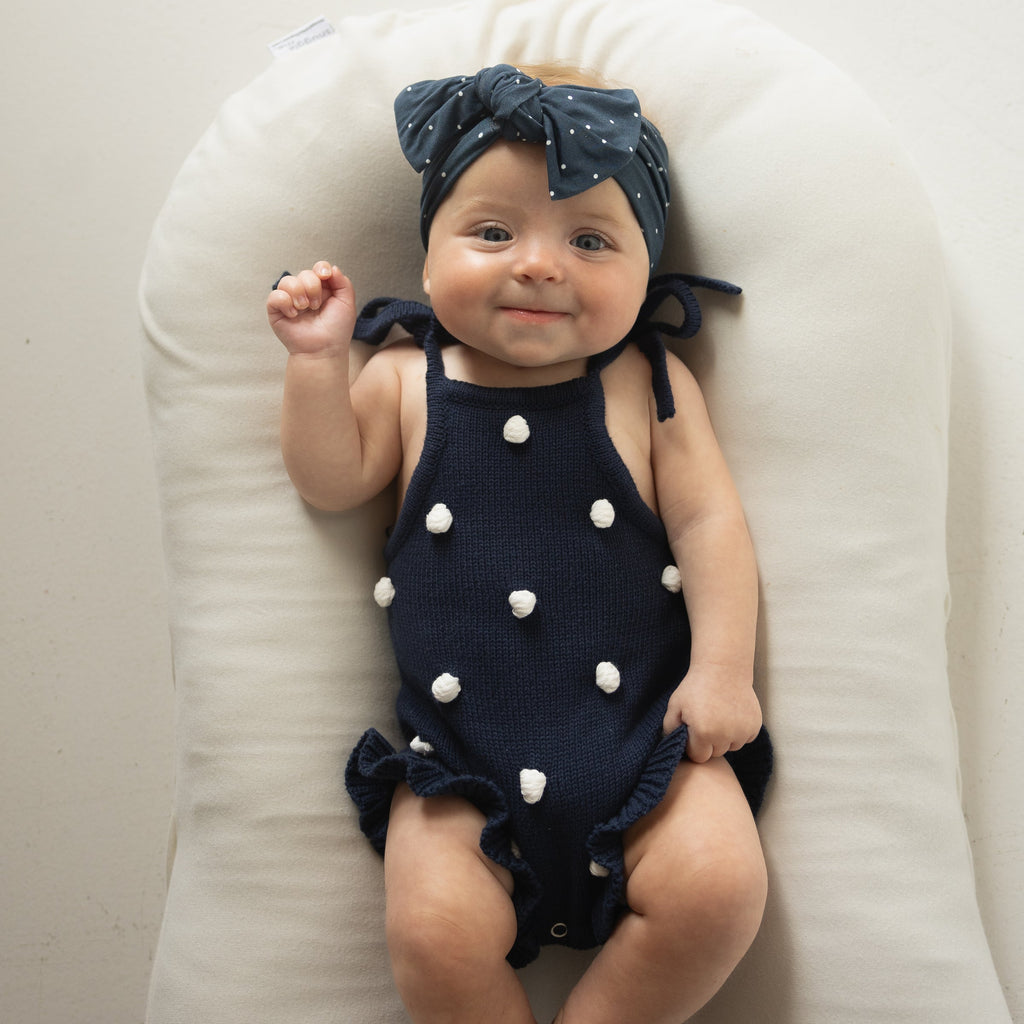 Emery Knit Ruffle Romper in Navy Blue with Cream Pom Poms