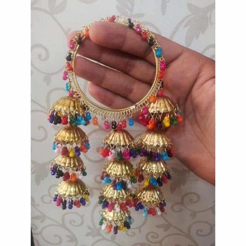 Set of multicolor pearl bangles with gold jhumka charms for festive ethnic wear.