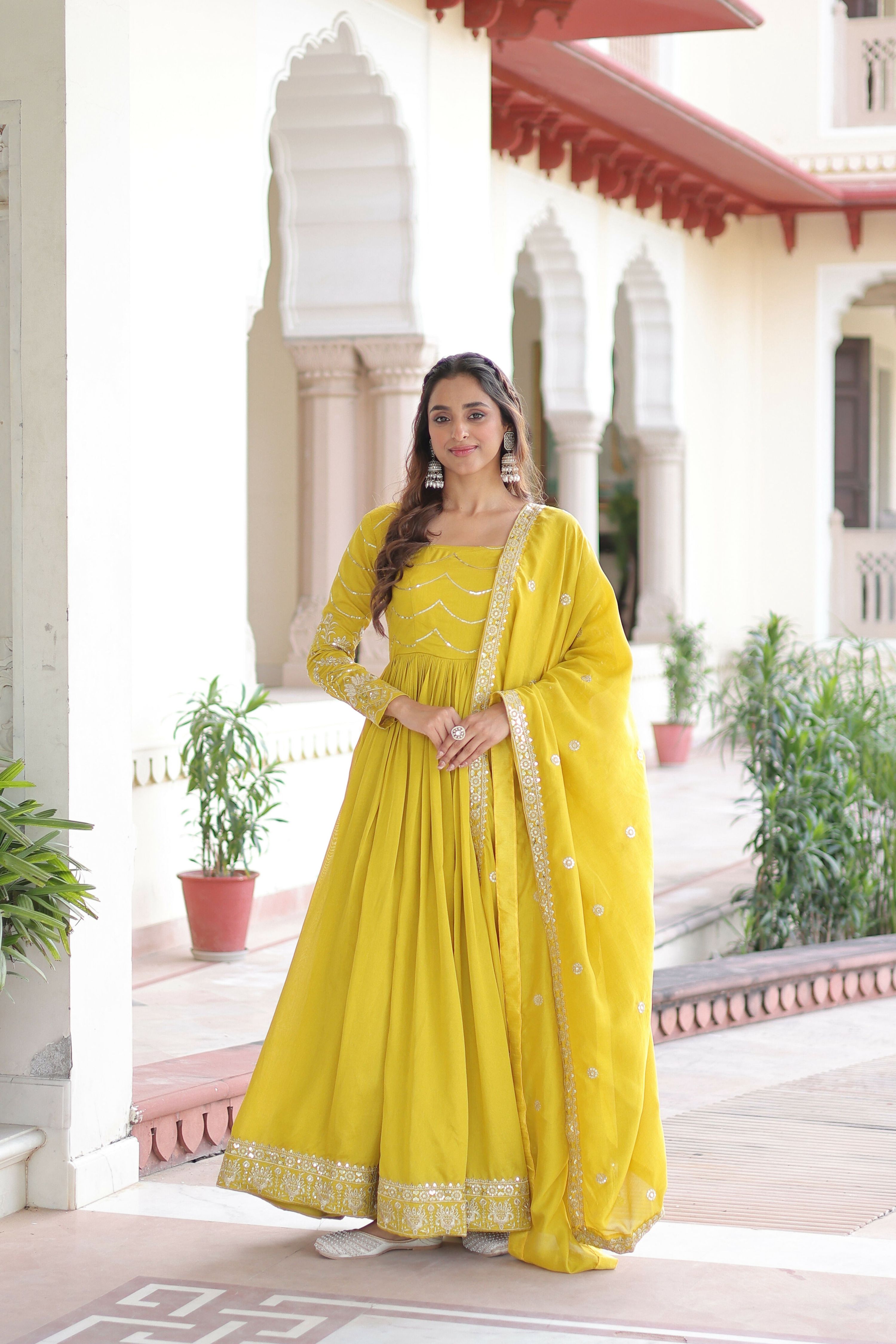 Woman wearing a vibrant yellow silk readymade kurta set with intricate sequence embroidery work