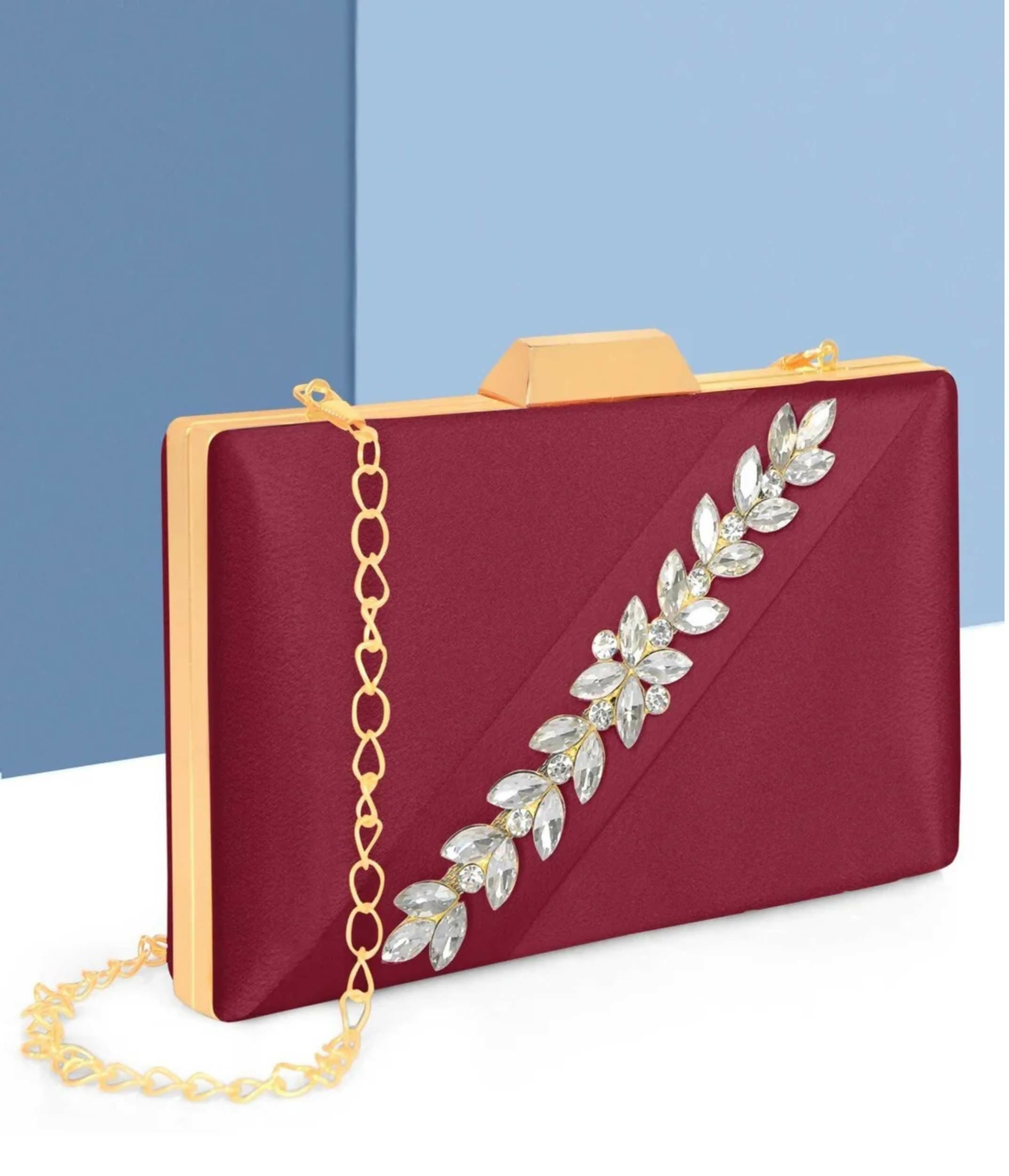 Pink satin evening clutch with a detachable metal chain strap against a neutral background