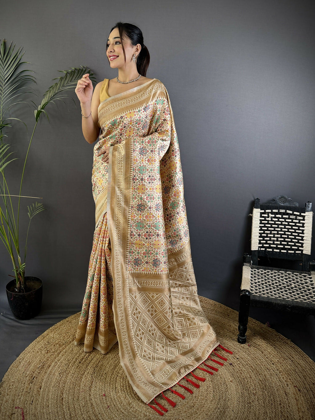 A cream soft silk Banarasi saree with intricate floral woven motifs and a matching blouse.