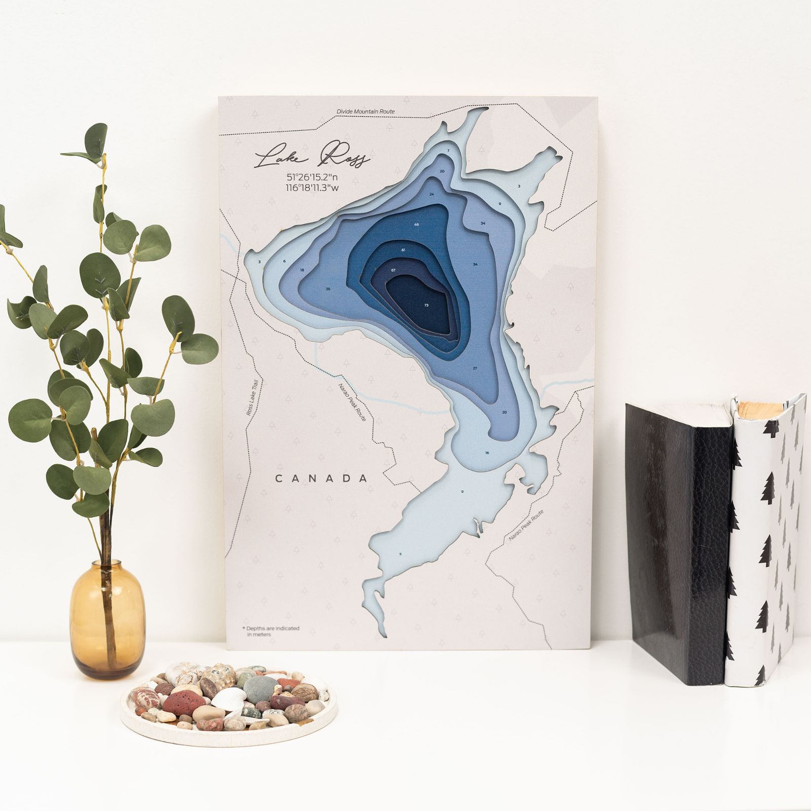 Detailed wooden map wall art of Lake Ross Canada hanging on a neutral wall.