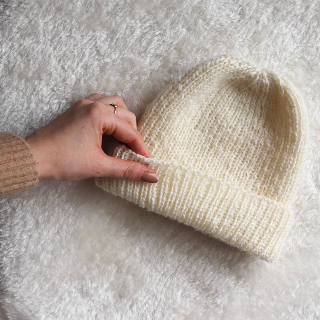 Minimalist cream ribbed knit hat in a cozy, relaxed fit for fall and winter styling.