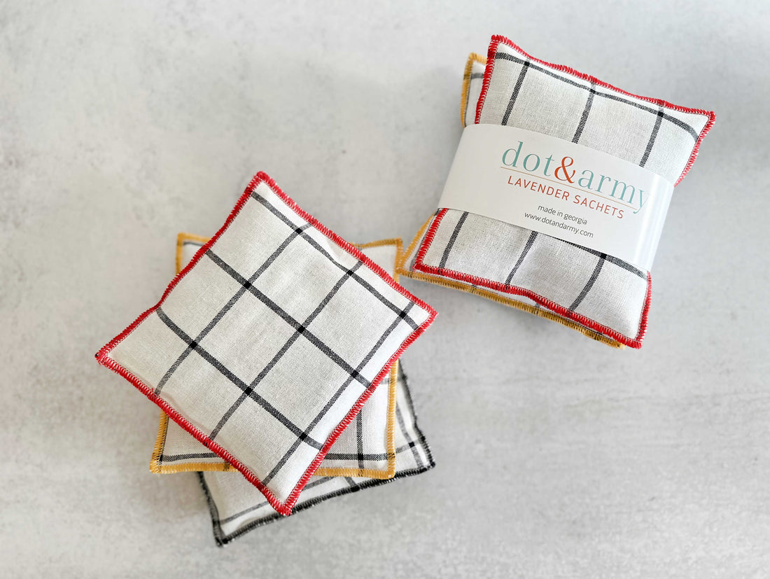 A set of two linen lavender sachets featuring a windowpane pattern and colorful edge stitching.
