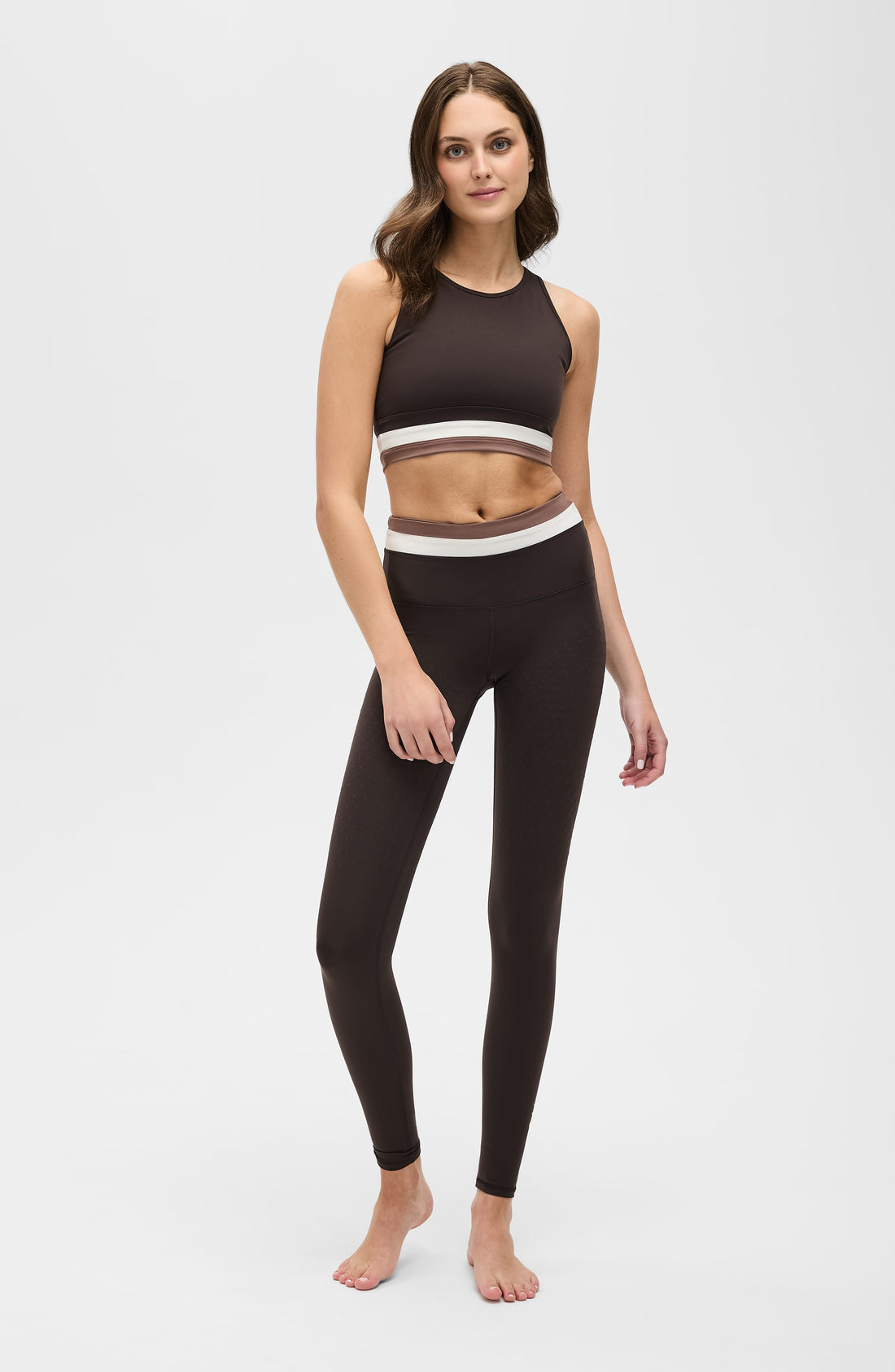 Woman wearing Le Monde sculpting high-waist leggings in espresso, white, and blush colorways.