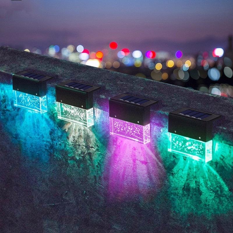 Modern black LED solar fence light glowing in a minimalist garden setting