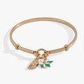 Gold tension bangle featuring a yellow crystal-encrusted lemon wedge charm and a white flower charm.