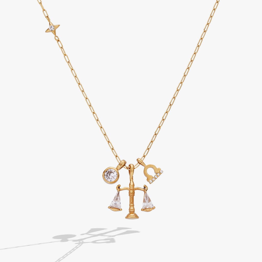 Gold-plated Libra zodiac necklace featuring a scale charm with clear crystal triangle accents