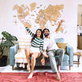 3D wooden world map in gold finish mounted on a modern living room wall