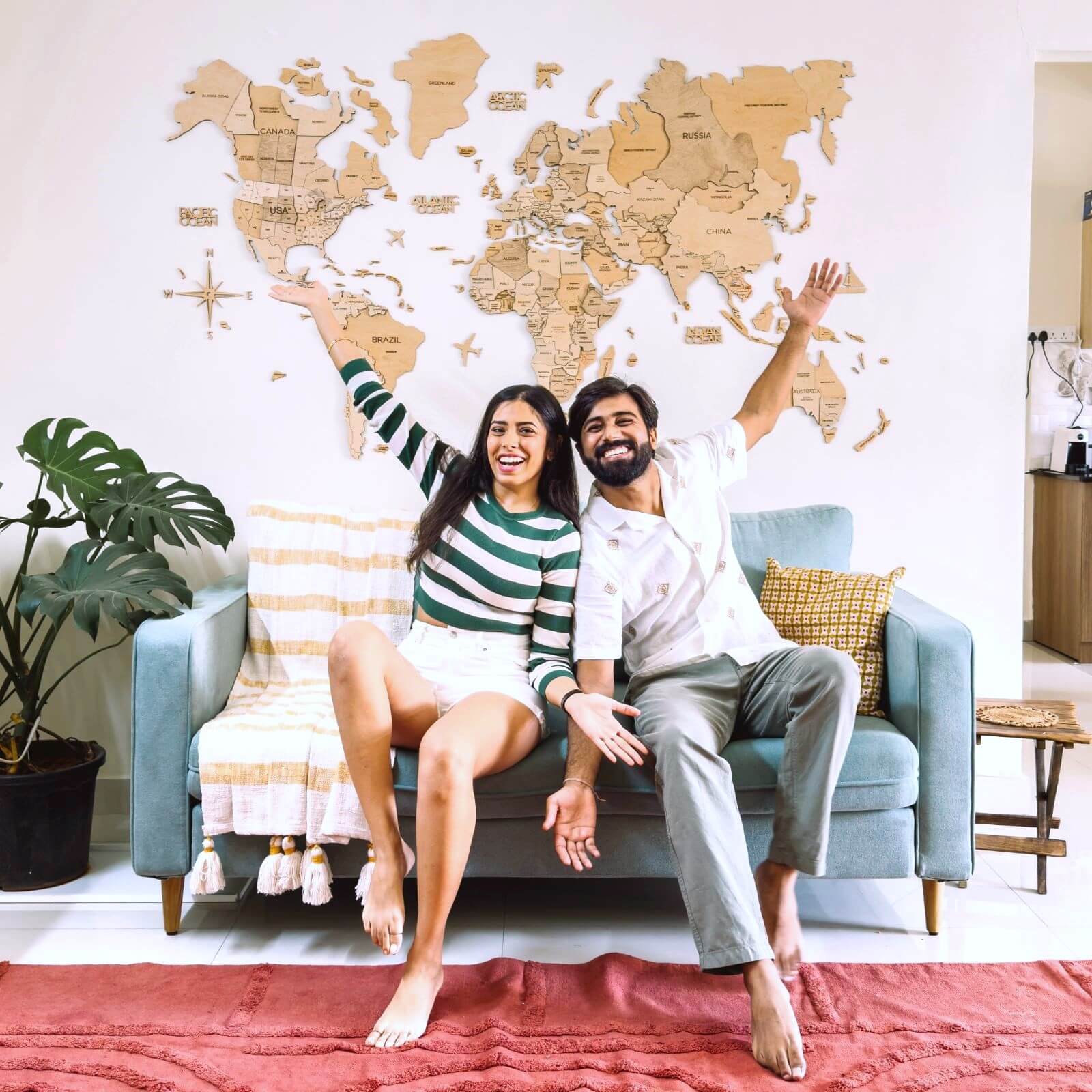 3D wooden world map in gold finish mounted on a modern living room wall