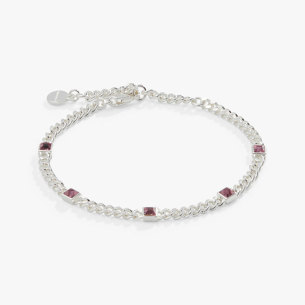 Close up of a light amethyst gemstone set in a classic polished curb chain bracelet