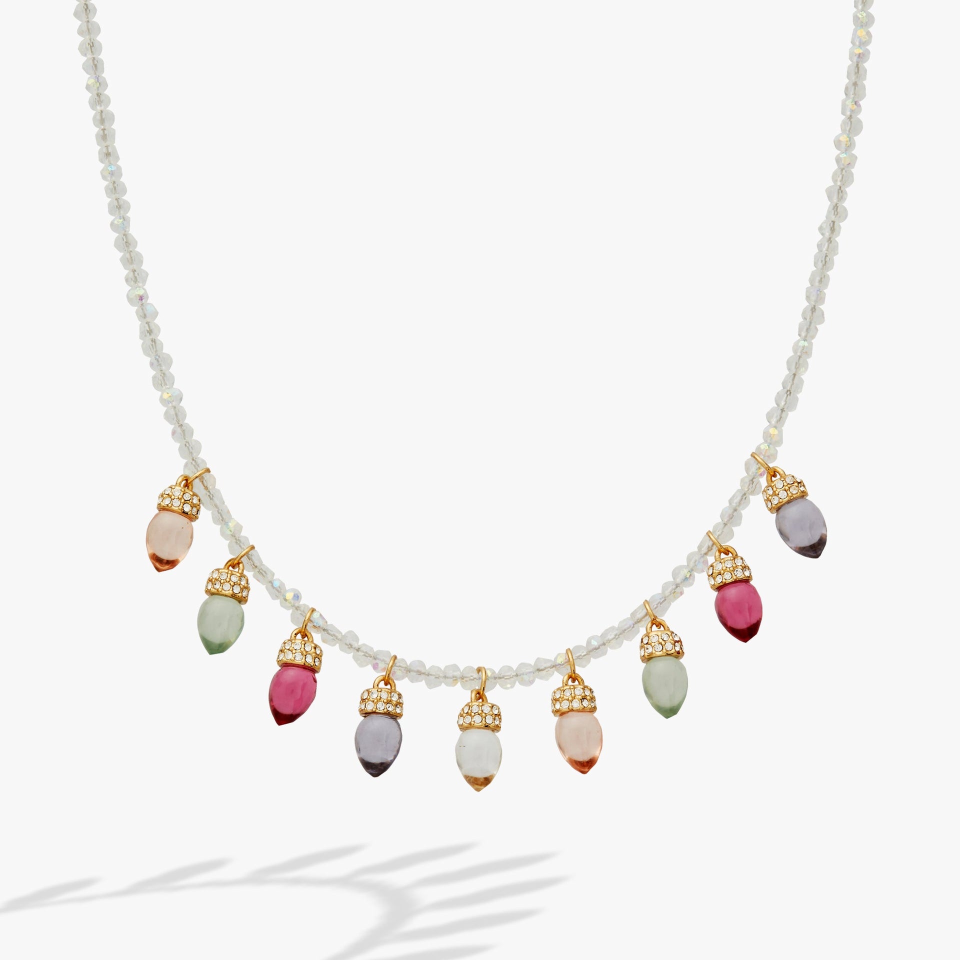 Close up of a Christmas light bulb necklace with clear beads and muted resin accents.