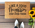 Funny tan and black doormat with the text Like A Good Neighbor Stay Over There