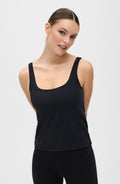 Model wearing a minimalist black Lisse compression tank with a sculpting fit, seen from the front.