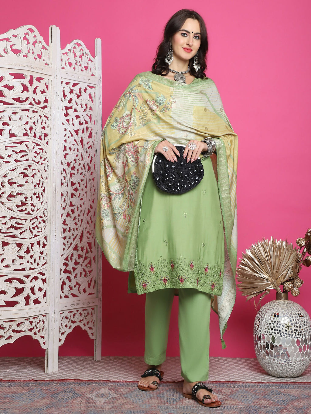 Woman wearing a green muslin straight kurta with floral prints and resham embroidery with trousers and dupatta