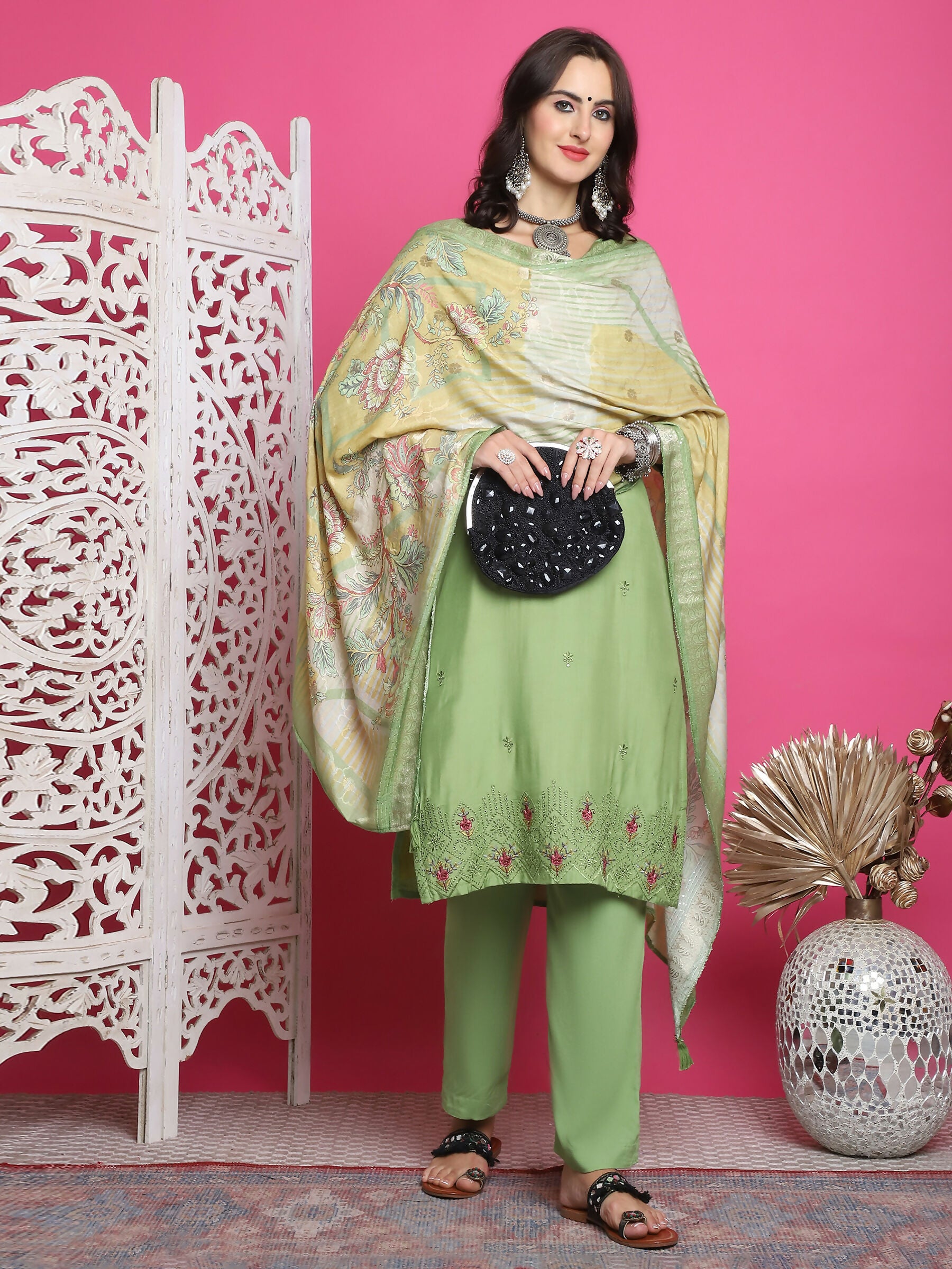 Woman wearing a green muslin straight kurta with floral prints and resham embroidery with trousers and dupatta