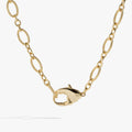 Chunky gold-tone lobster claw design convertible necklace and layered wrap bracelet on a white background.