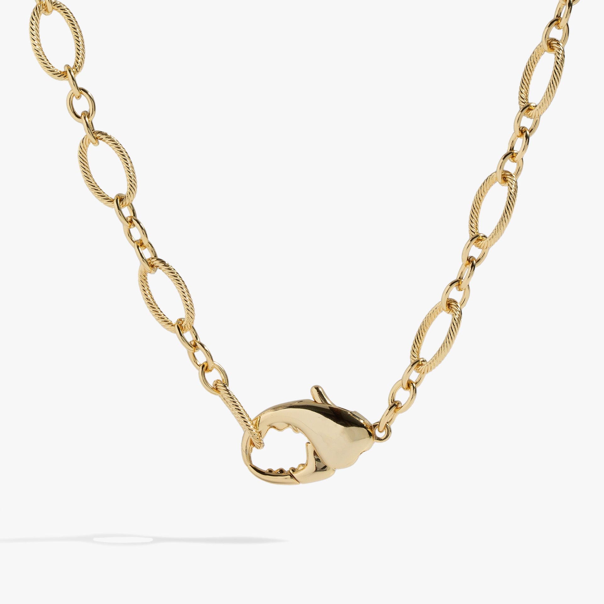 Chunky gold-tone lobster claw design convertible necklace and layered wrap bracelet on a white background.