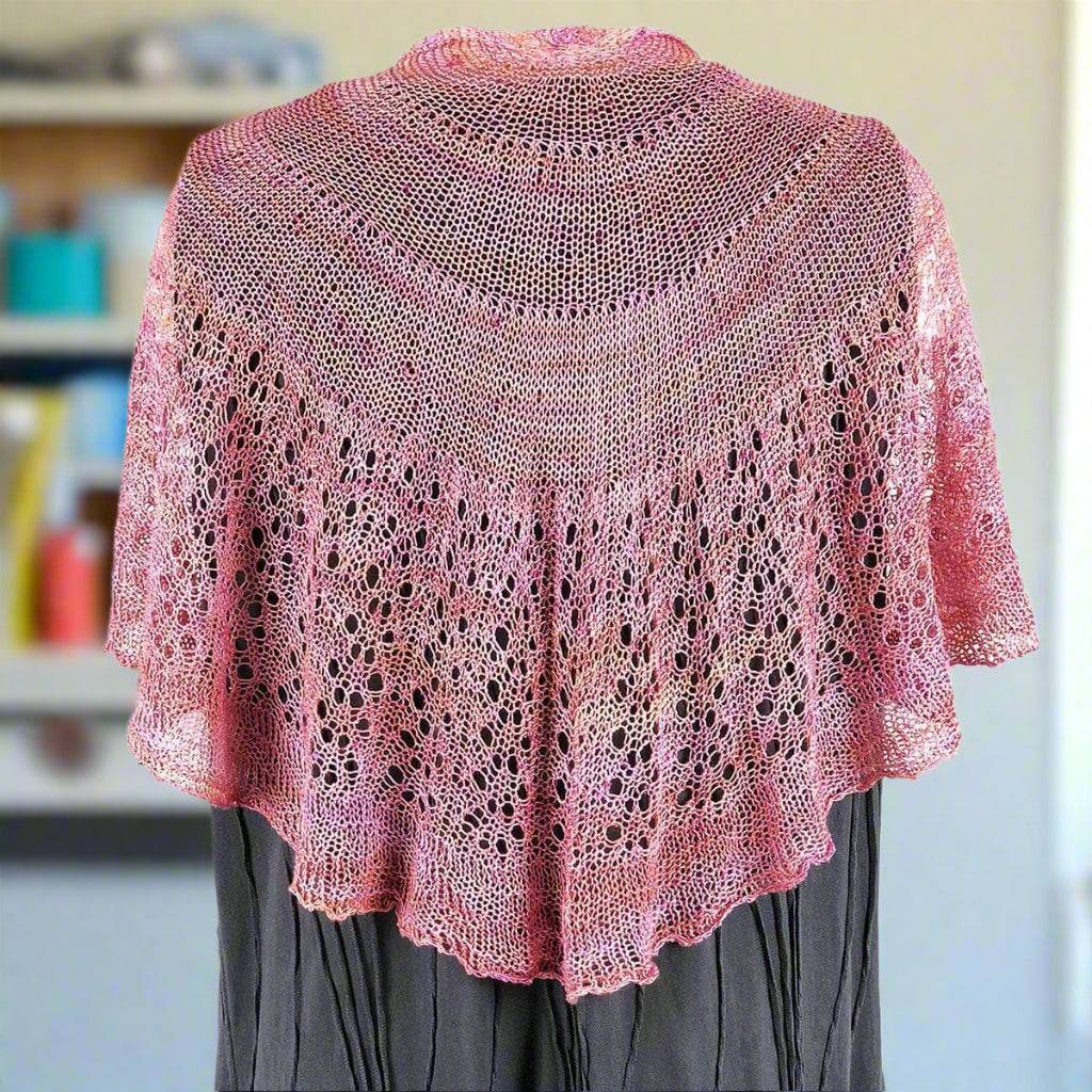 Close-up of the intricate Lotus Lace shawl knitting pattern featuring hand-beaded silk yarn.
