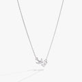 Delicate silver love letter pendant necklace featuring a swallow charm and a round crystal on a cable chain.