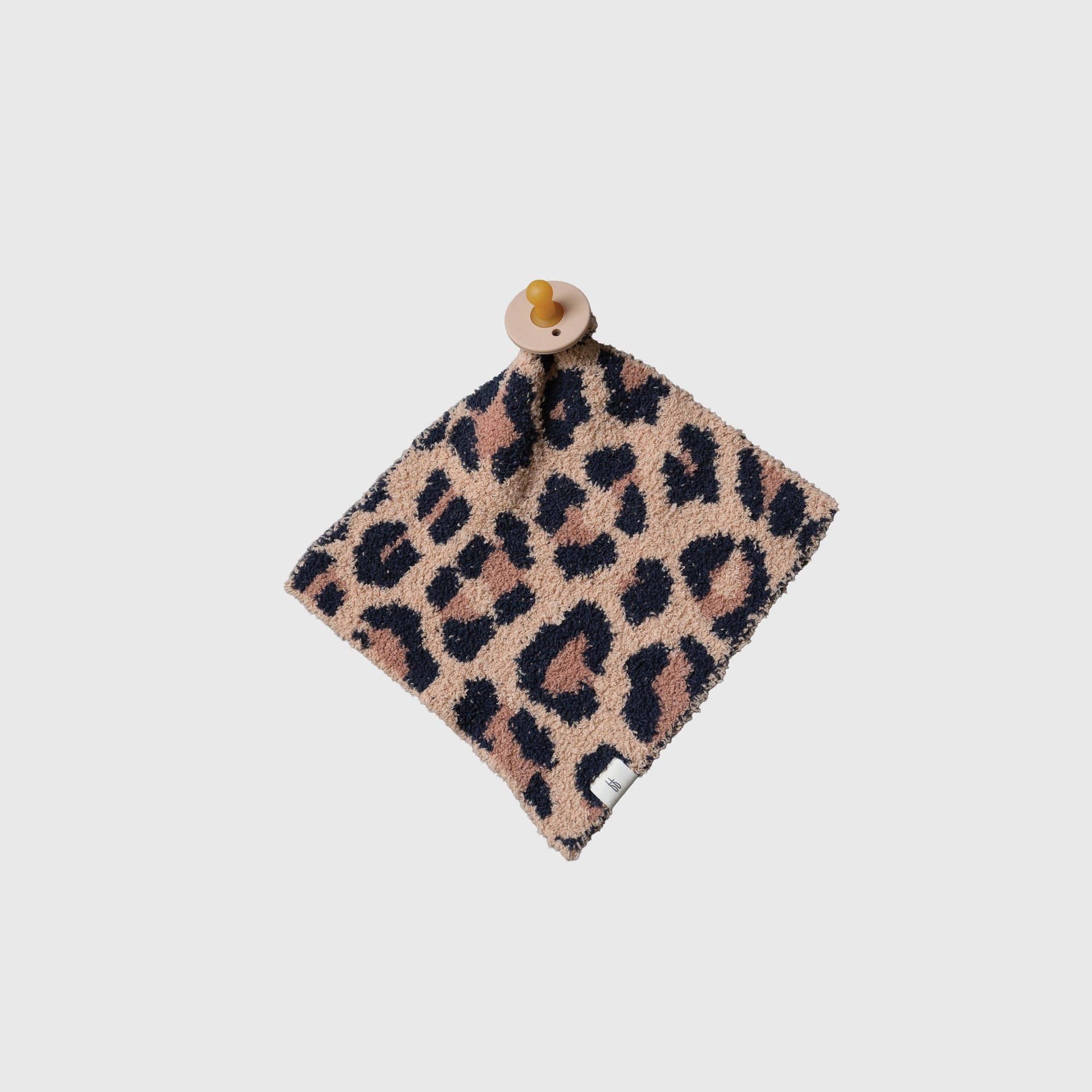 Soft leopard print knit lovey for babies in warm earth tones, displayed in a modern nursery setting.